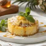 A beautifully plated pineapple dessert with fresh mint and coconut flakes.